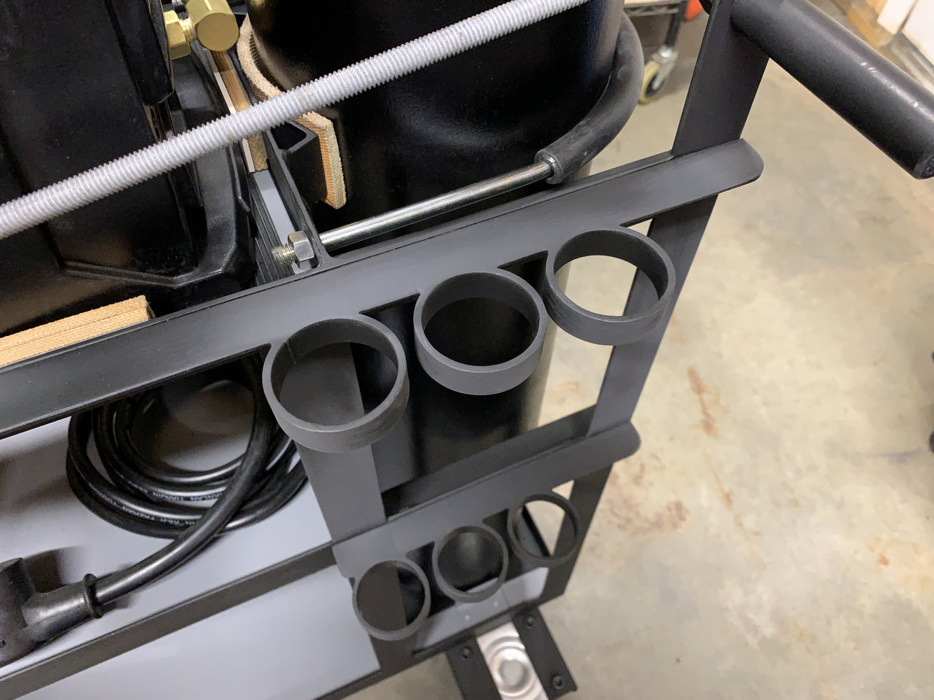 Rings installed on sides of trolley to hold filler-rod tubes.