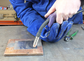 Holding the welding torch in both hands